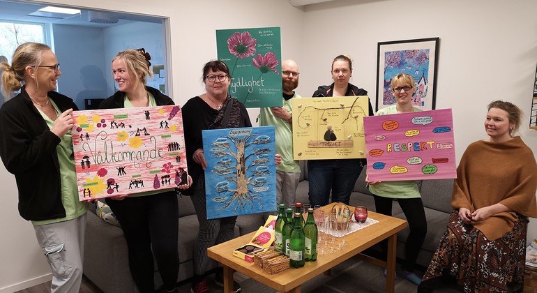 Personal håller upp kreativa gruppens tavlor