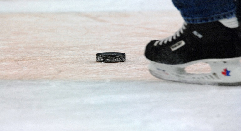 Foto: Pixabay. Foto visar en svart/vit skridsko samt en ishockeypuck på is.