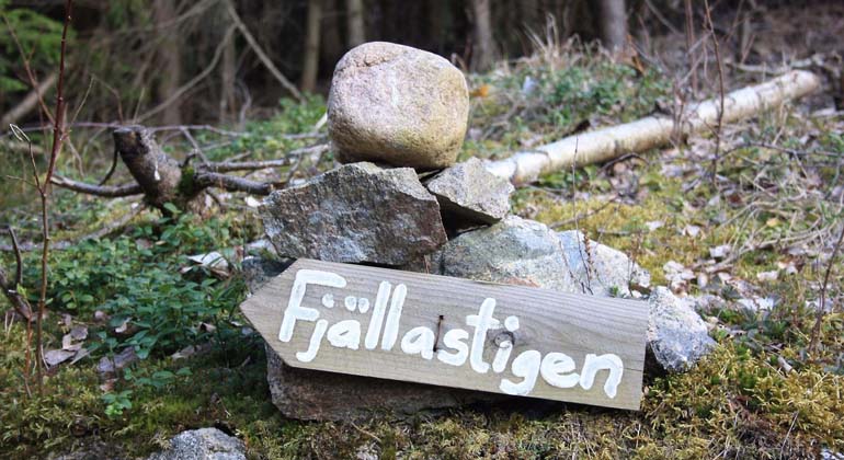 Skylt Fjällastigen i skogen