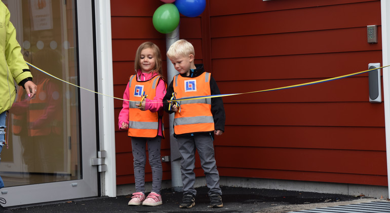 Två barn klipper band