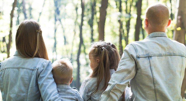 Barnfamilj som sitter utomhus