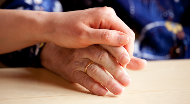 Två personer som håller hand