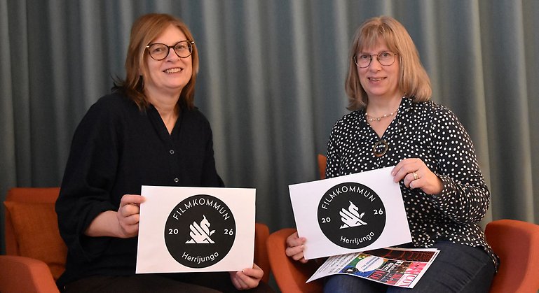 Två personer håller upp bild på texten filmkommun 20206